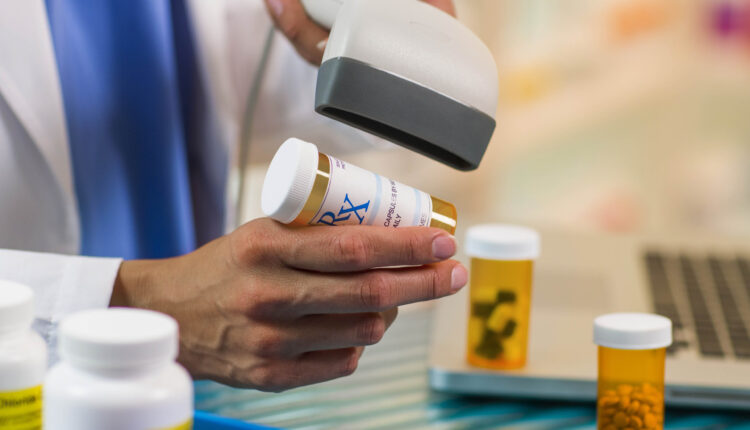 A close-up of a pharmacist scanning a prescription.